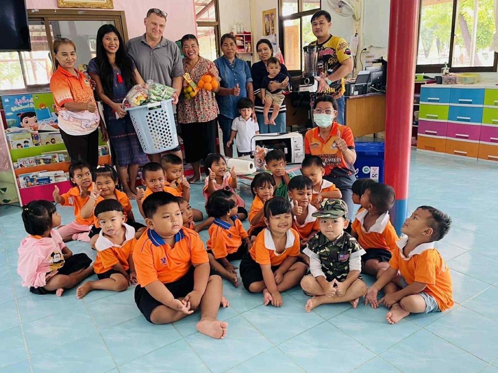 Benjamin Cunningham and community members visiting a kindergarten in Thailand with donated supplies